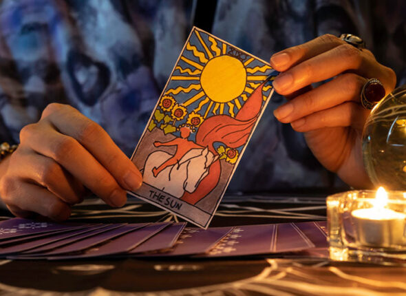 fortune-teller-hands-holding-sun-card